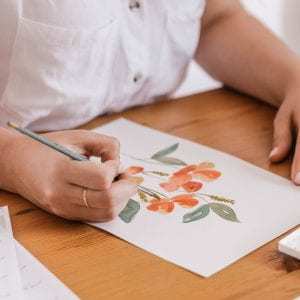 person using waterpaints to draw flowers